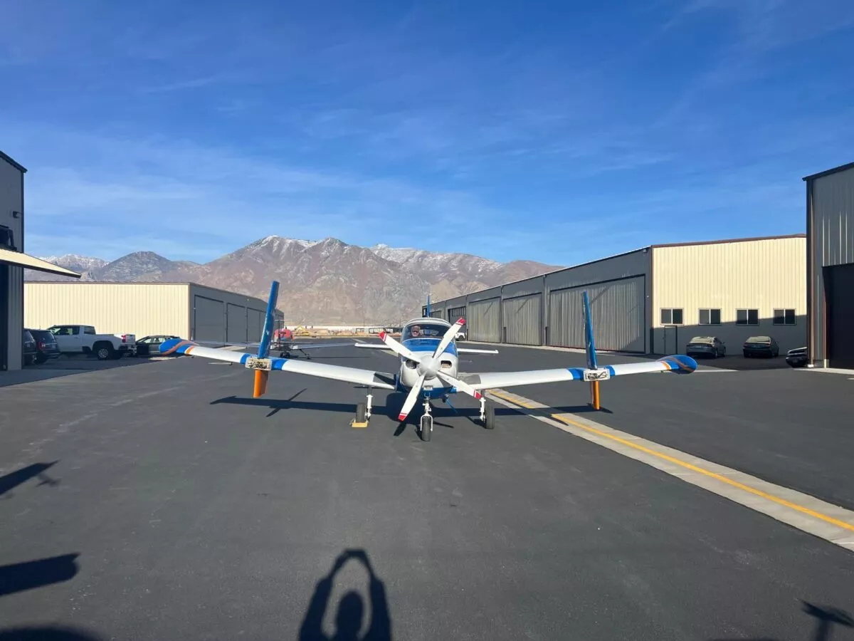 Small plane on runway with mountains behind.